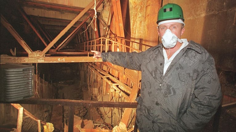 An investigator points toward damaged Reactor No. 4 inside the Chernobyl nuclear power plant in Chernobyl, Ukraine, Nov. 10, 2000. 