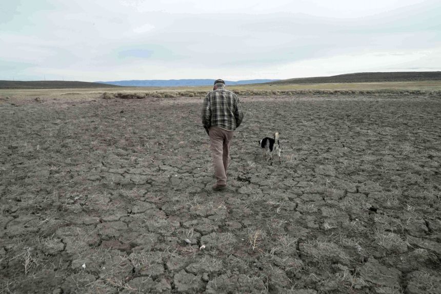Philip Anderson walks across a dry stock pond in Walden, Colorado, on March 31.