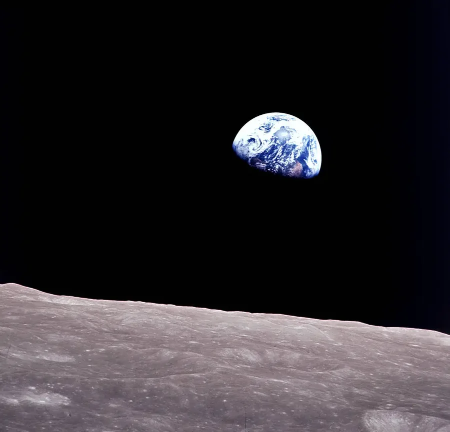 A gibbous Earth seen hovering above a stark gray lunar surface.