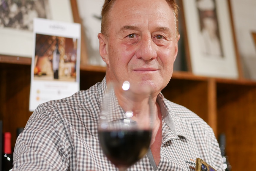 A man holding a glass of red wine