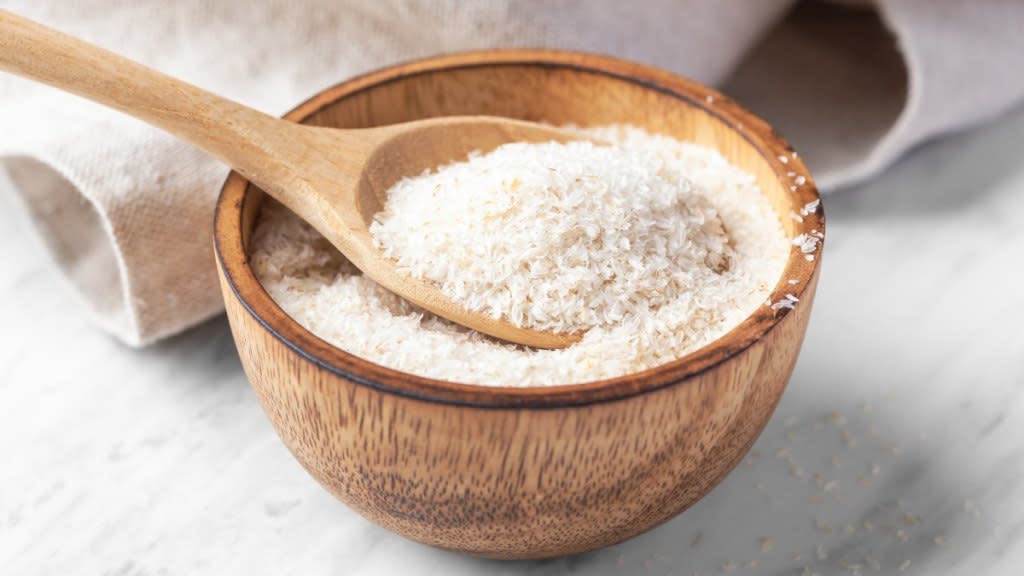 close-up of psyllium husk, the best fiber supplement to lower cholesterol, in a wooden bowl