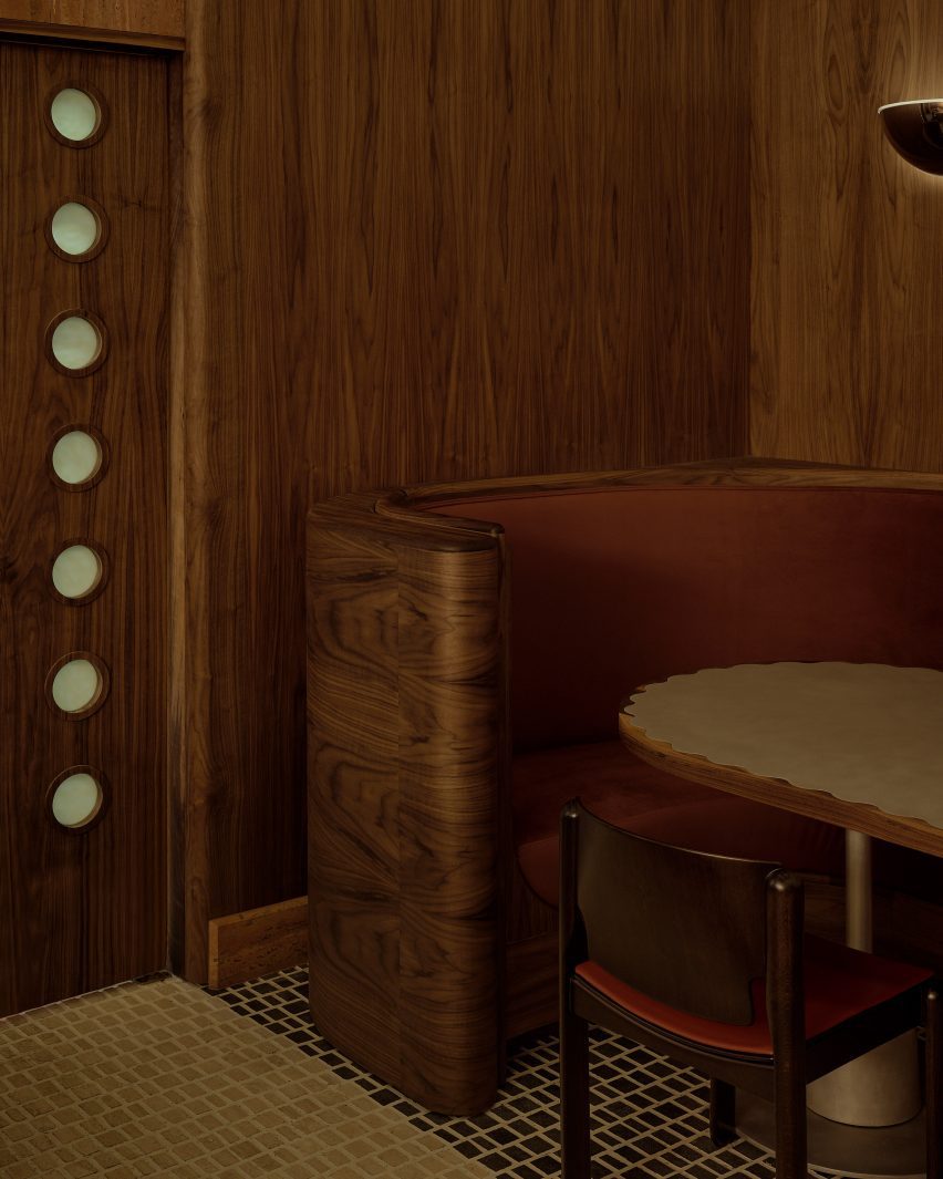 A restaurant corner with a scalloped-top table and frosted-glass inserts in the kitchen door