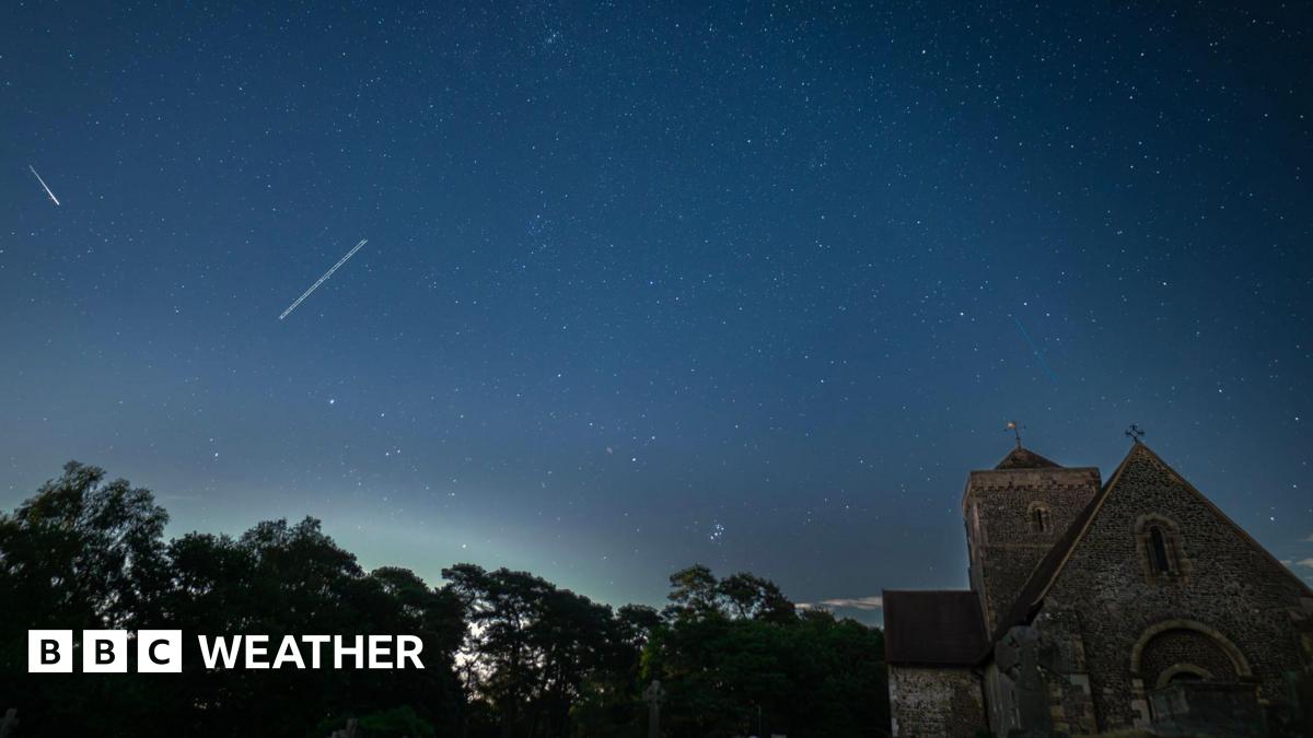 A tranquil nightscape capturing the starlit sky above an old English church graveyard. The silhouettes of weathered gravestones and the gothic architecture of the church create a serene yet mysterious foreground beneath a clear, star-filled sky. A peaceful fusion of history and the cosmos.