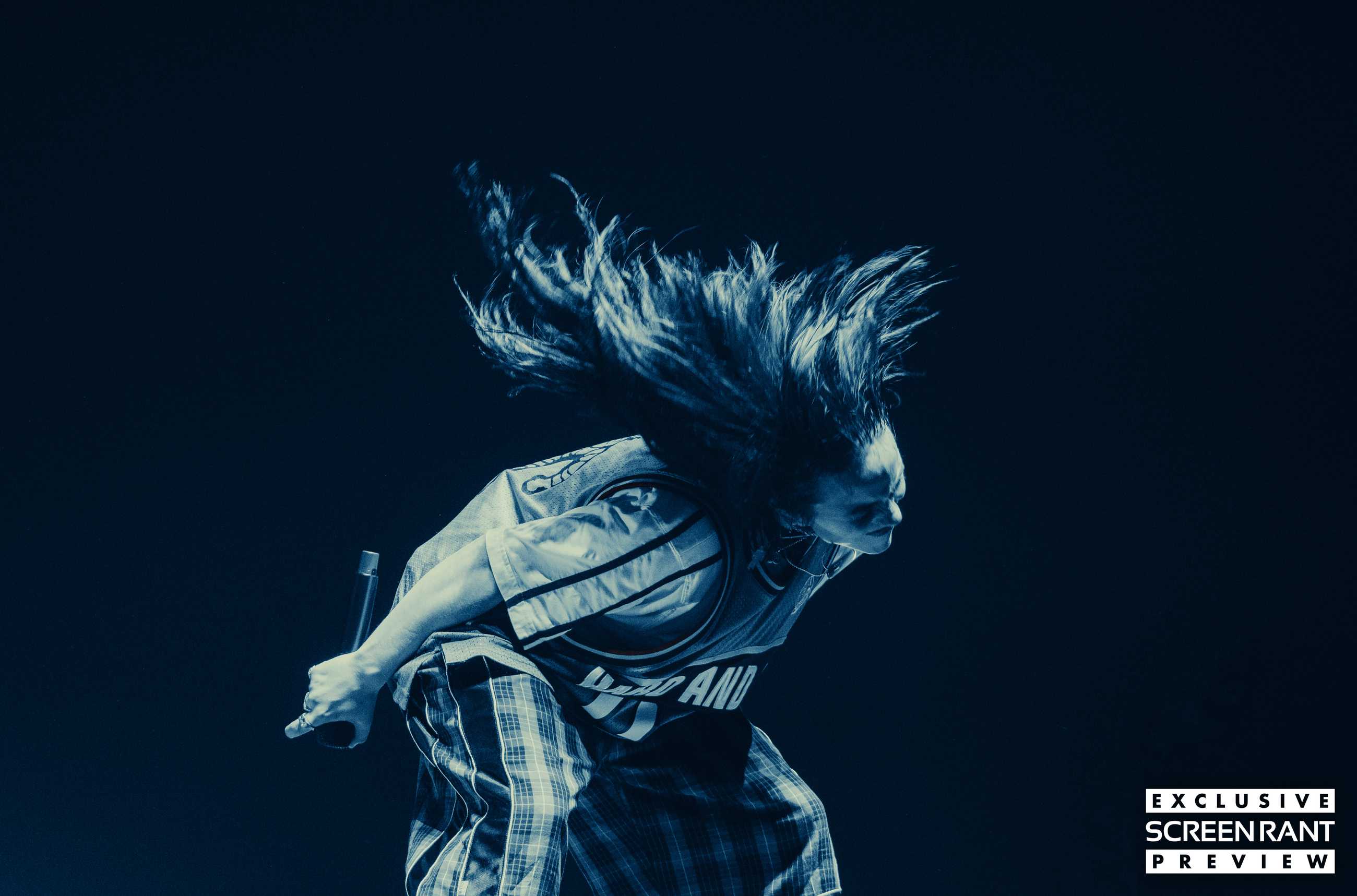 Billie Eilish lit with blue light whipping her hair