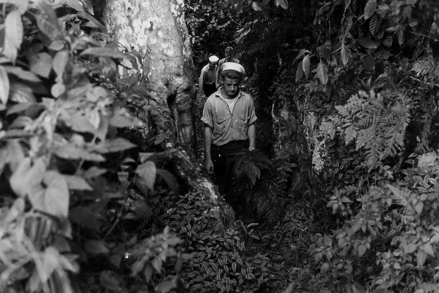 Black and white image of sailors walking in the jungle