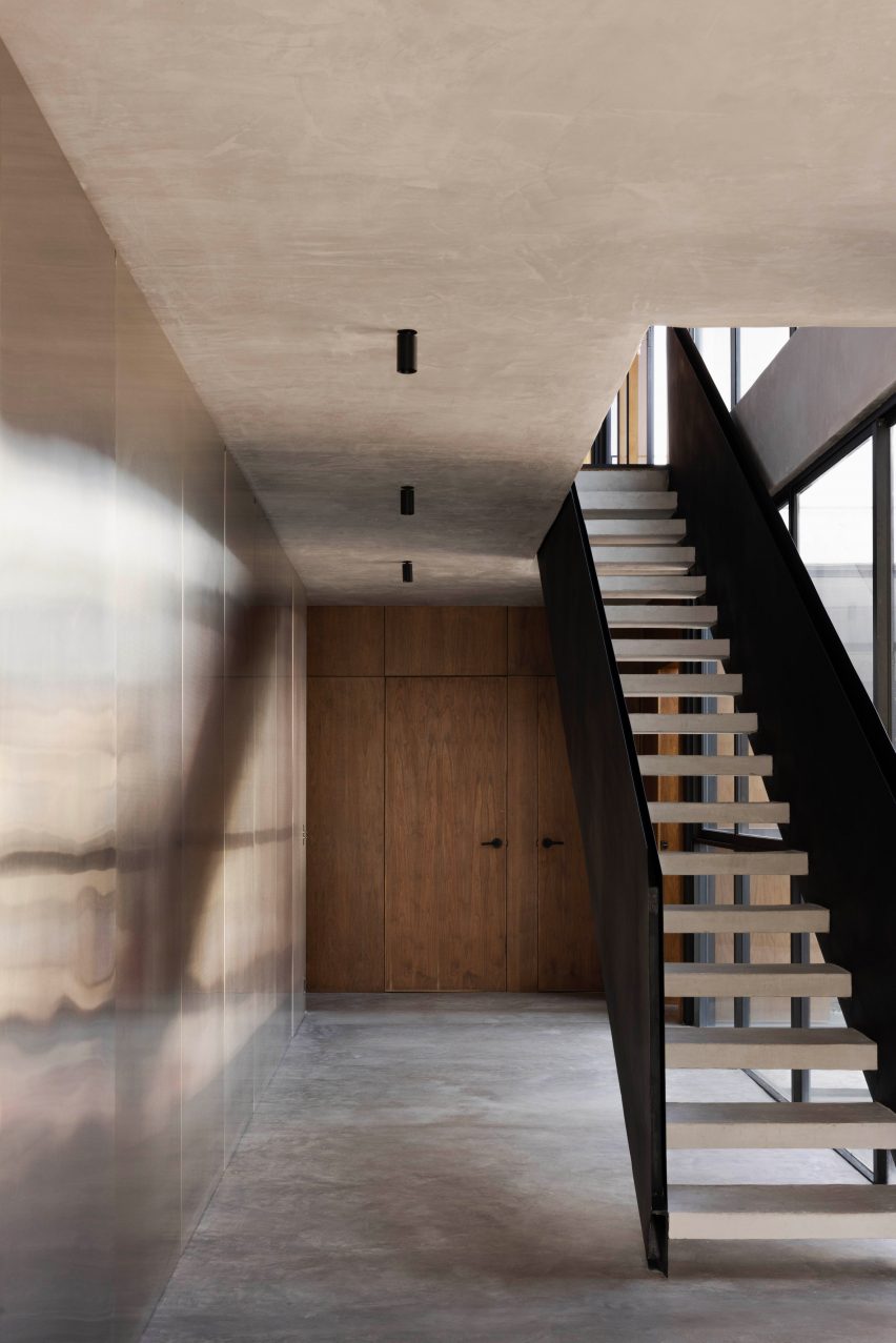 A staircase with black balustrades within a neutral-toned interior