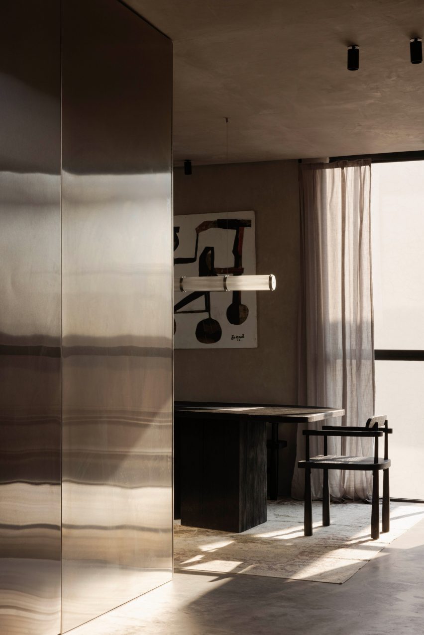 Stainless steel walls with a black dining table behind