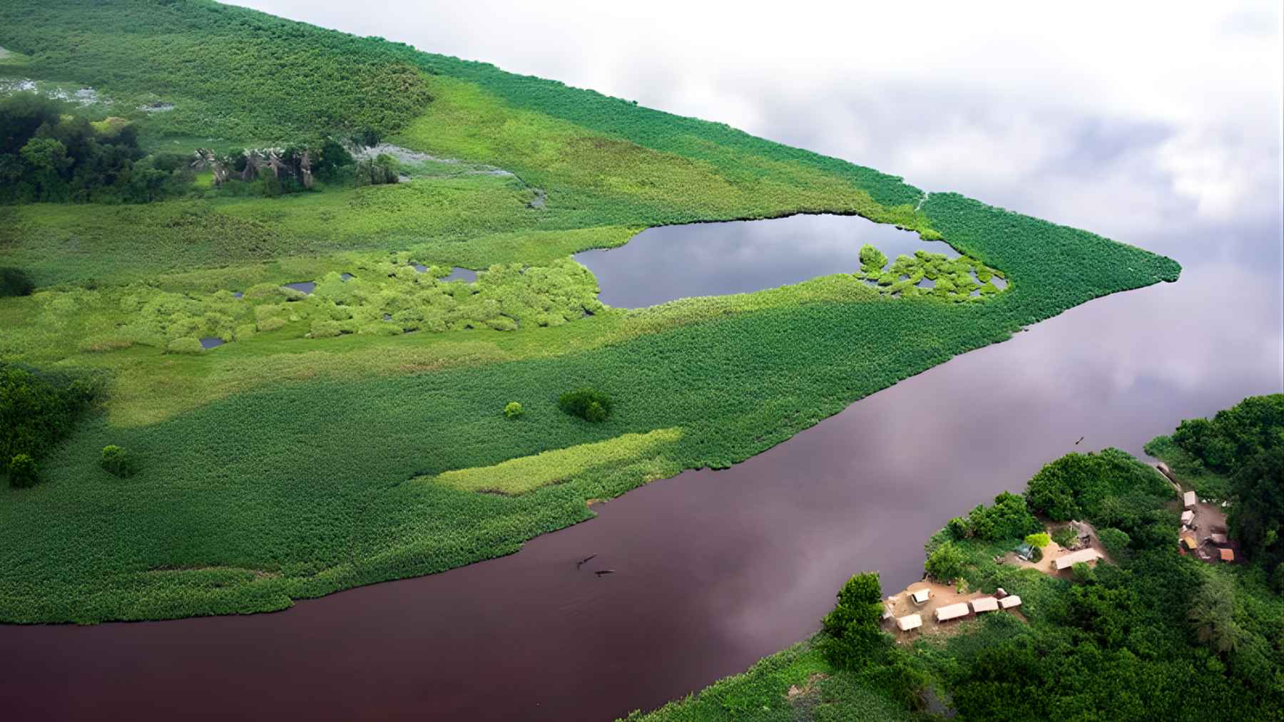 Aerial view of a dark lake and blackwater channel surrounded by vegetation in the Congo Basin