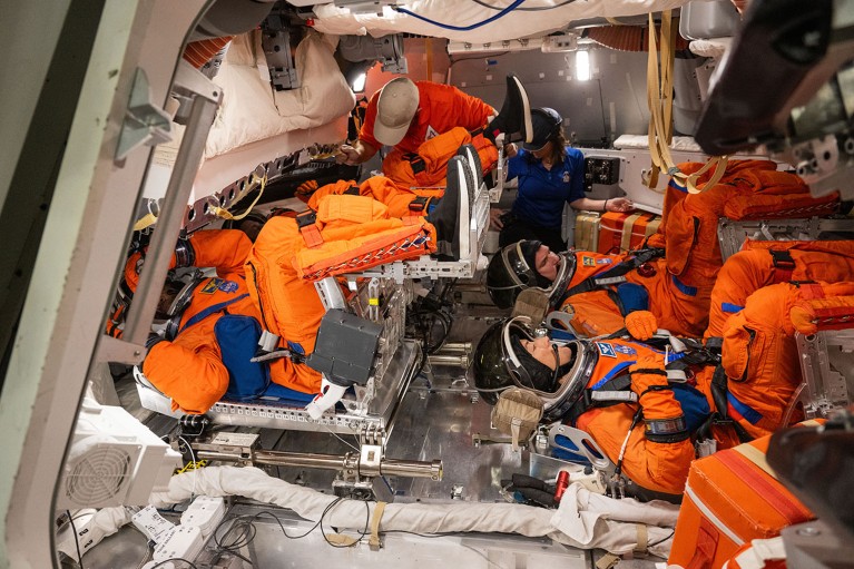 The Artemis II crew practice donning their Orion Crew Survival System spacesuits for post landing emergency egress.