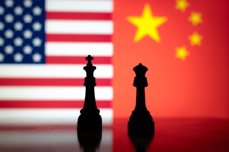King and queen chess pieces silhouetted against American and Chinese flags.
