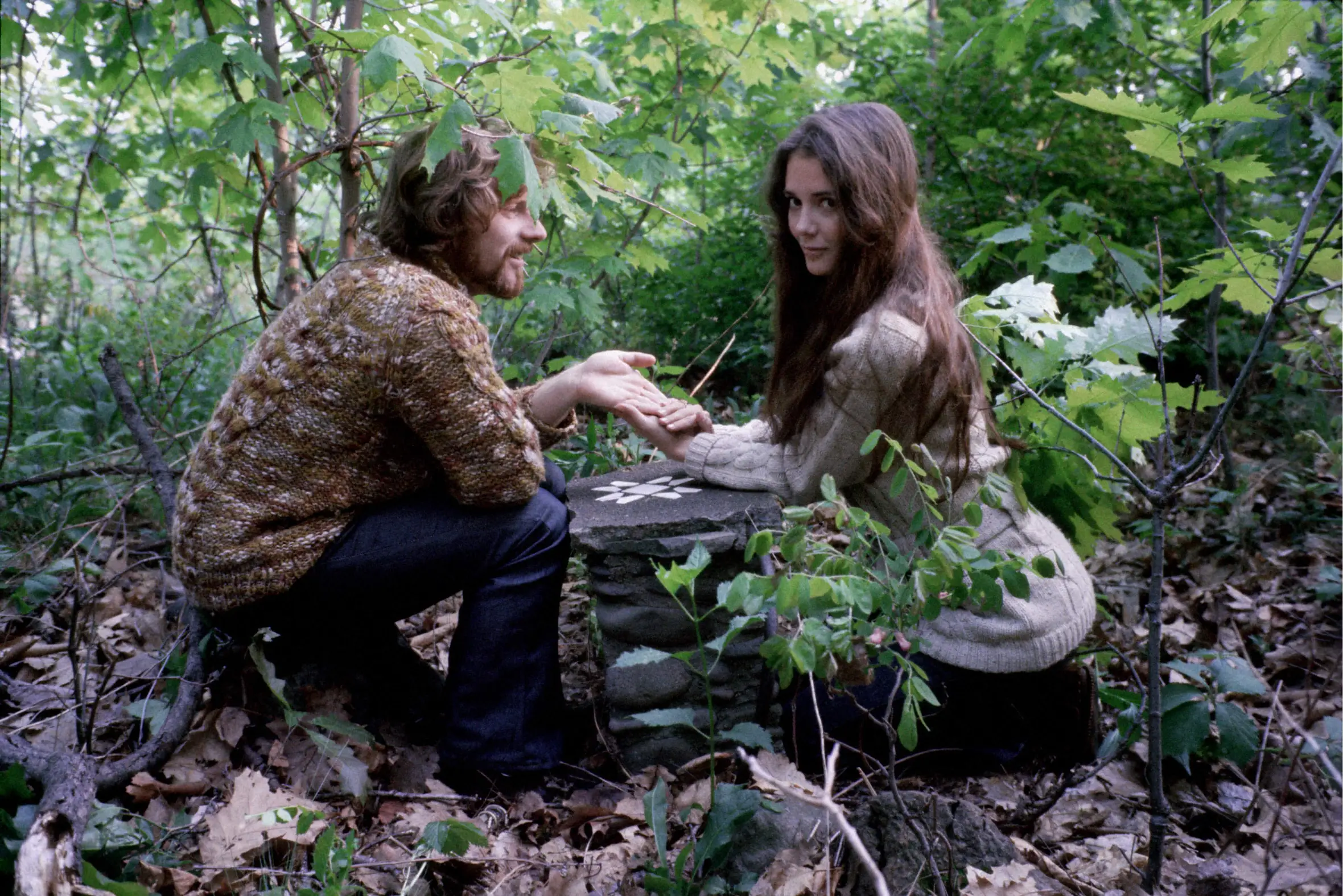 Van Morrison and Janet Planet holding hands in a forest.