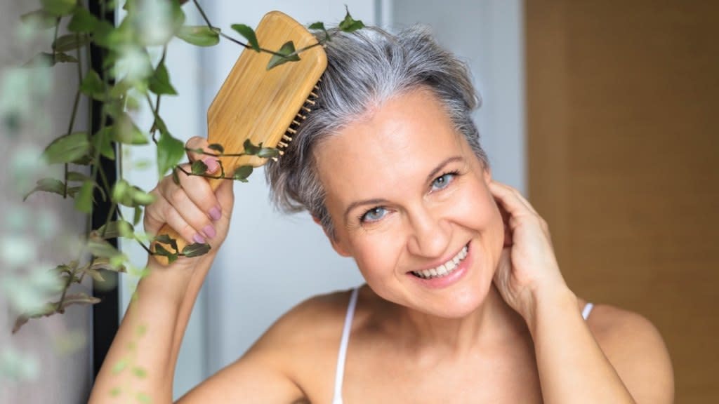 A woman brushing her hair after discovering the best hair loss treatments