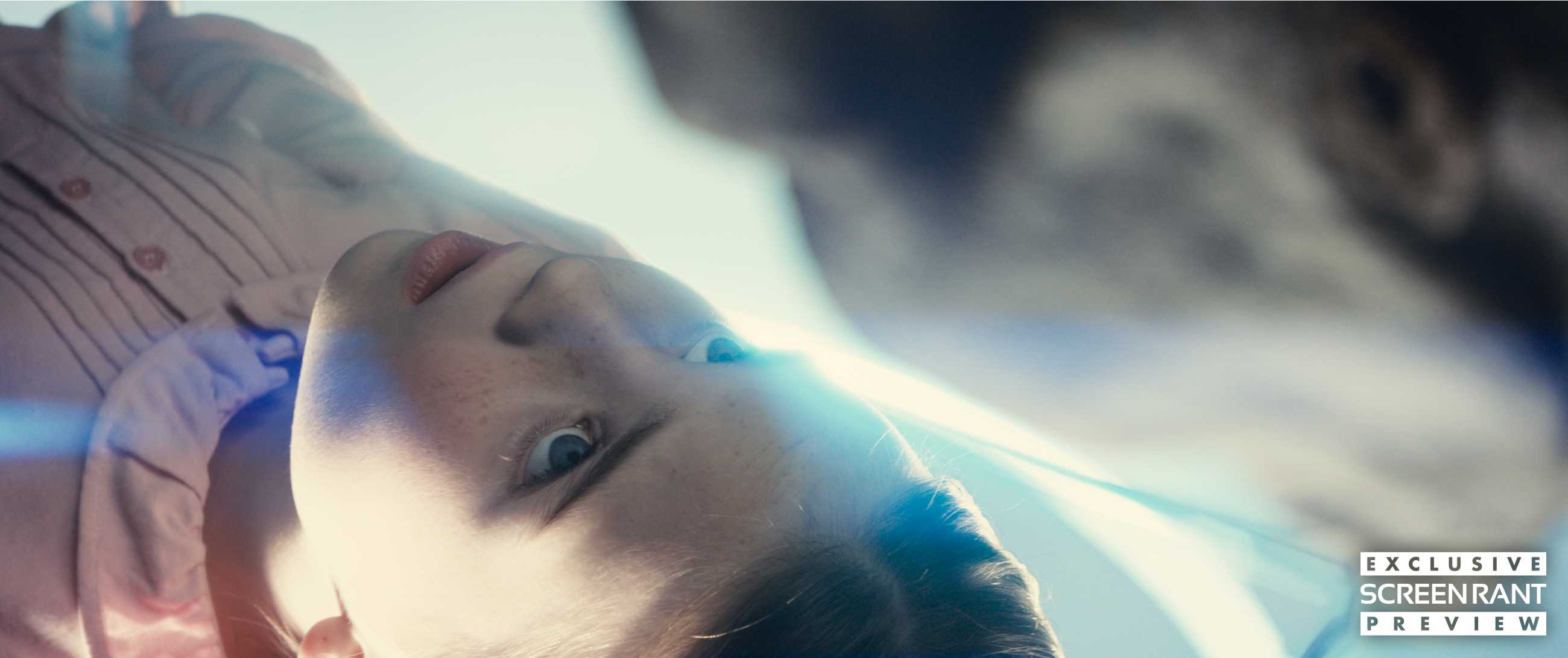 An alien leans over a young girl in Disclosure Day