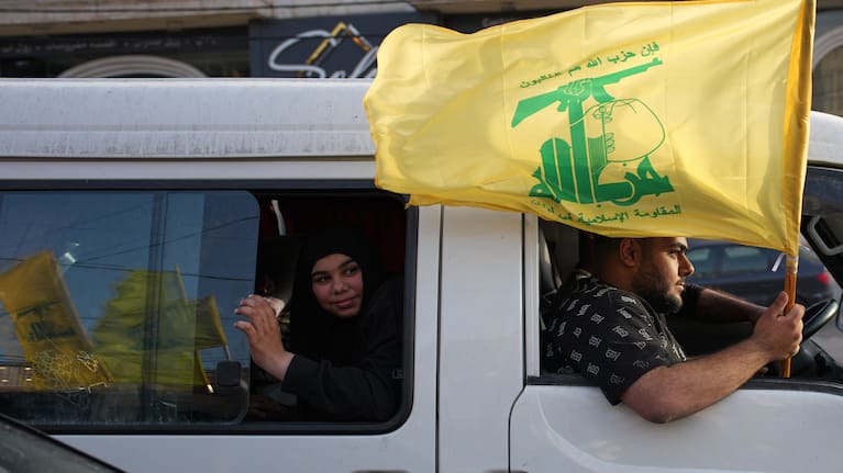 Displaced residents hold a Hezbollah flag as they celebrate while returning to their villages following a ceasefire between Israel and Hezbollah, in Zefta, southern Lebanon, Friday, April 17, 2026.