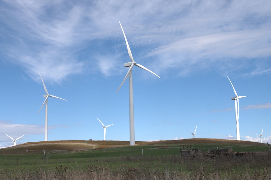 Wind turbines on a green hill. 