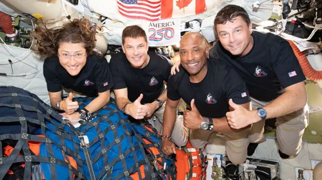 The four Artemis II astronauts smile and pose aboard the spacecraft