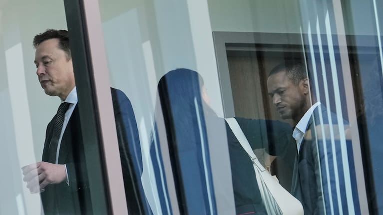 Elon Musk walks through a hallway inside the US District Court in Oakland, California.