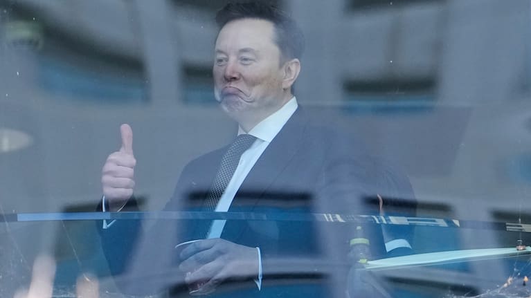 Elon Musk walks through a hallway inside the US District Court in Oakland, California.