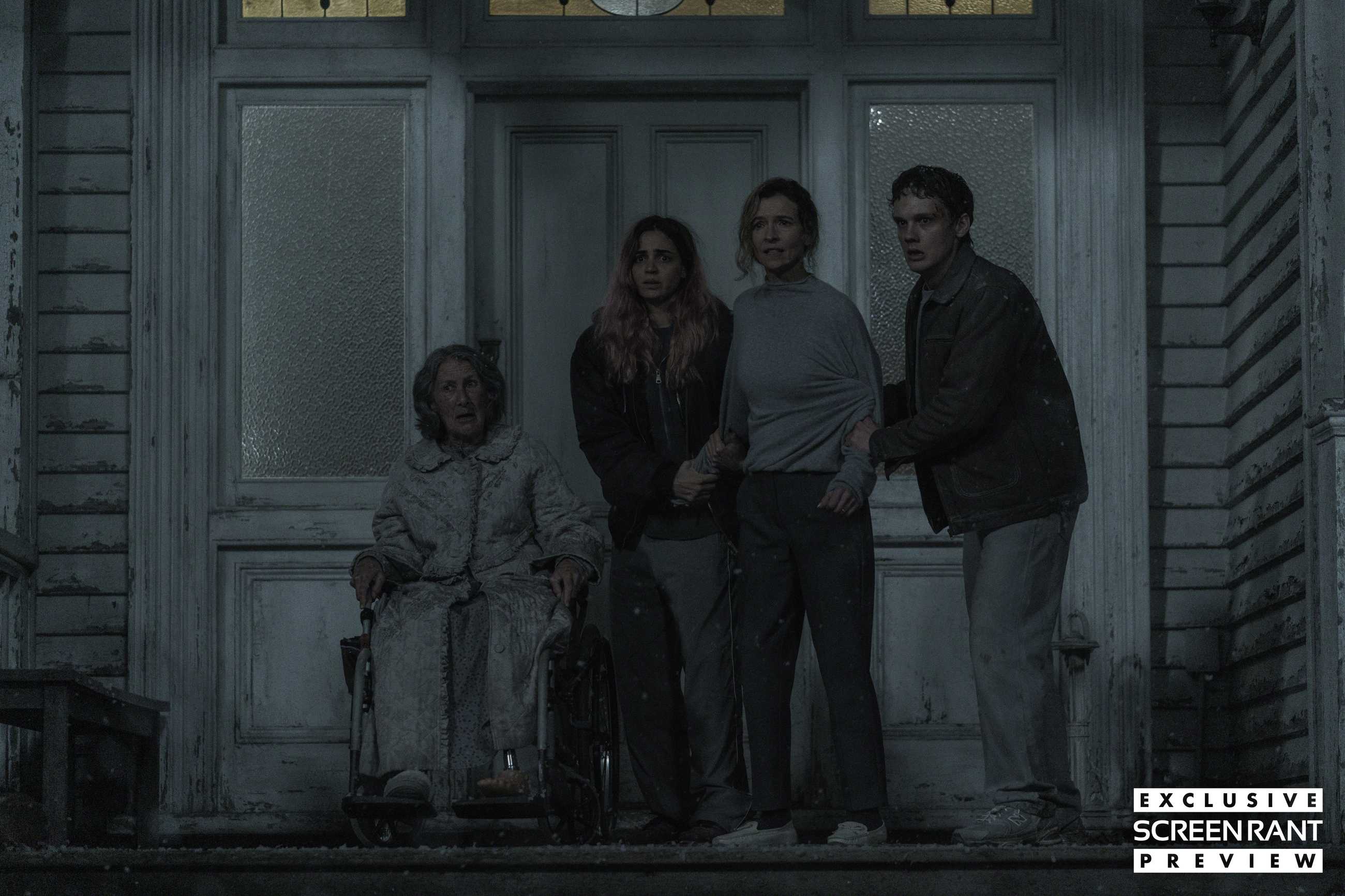 Four people huddle together fearfully on a porch in Evil Dead Burn