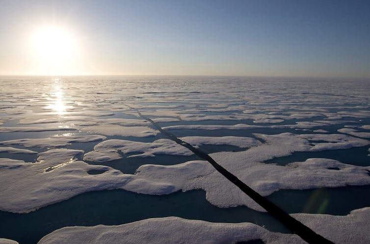 the sun shines above a sea covered with large blocks of ice