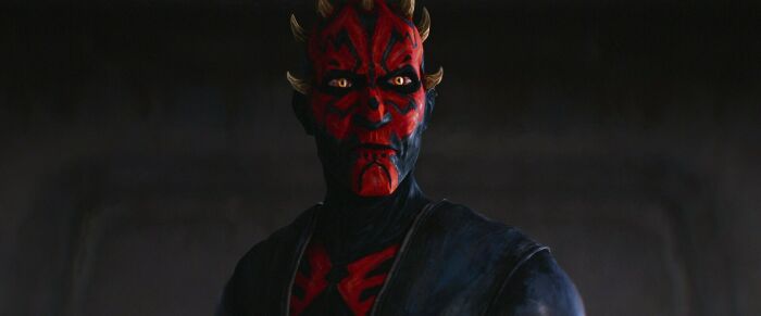 Star Wars Maul character in dark setting with red and black facial markings in a dramatic pose. Star Wars Maul character in dark setting with red and black facial markings in a dramatic pose.