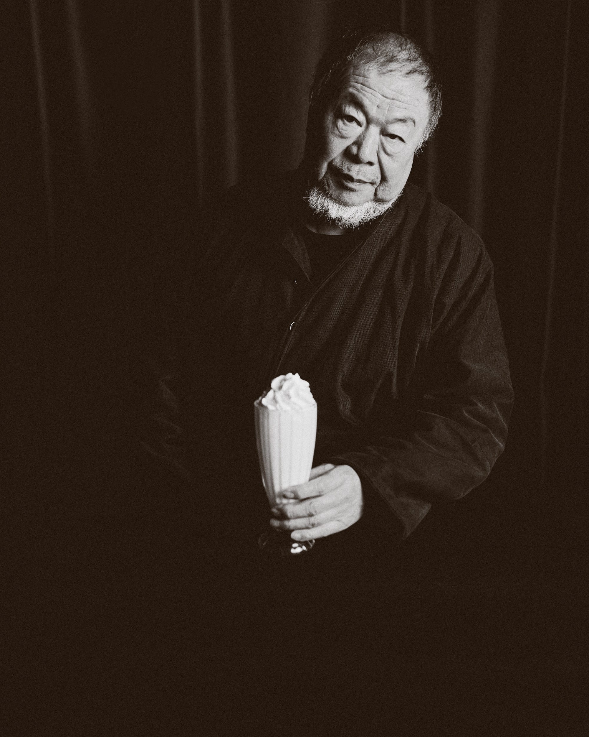 a black and white photo by Austn Fischer of ai weiwei holding a milkshake