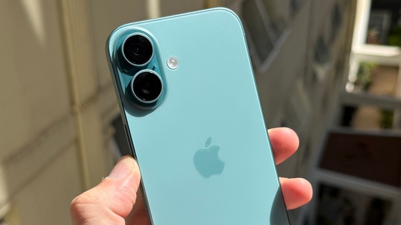 A hand holding an iPhone 16