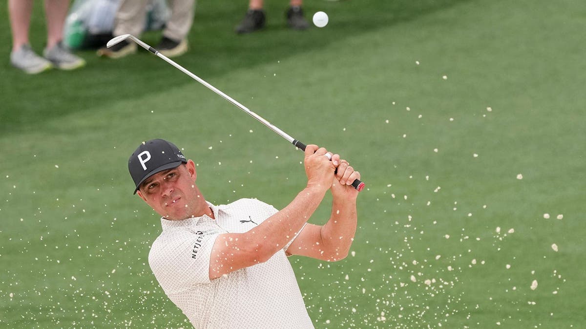 Gary Woodland hitting golf ball out of bunker at Augusta National Golf Club
