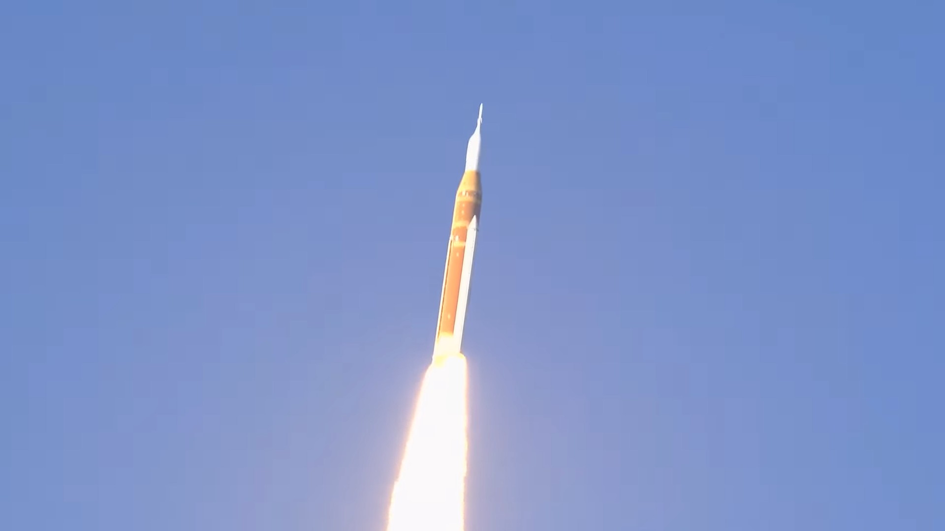 a rocket launches above a plume of fire
