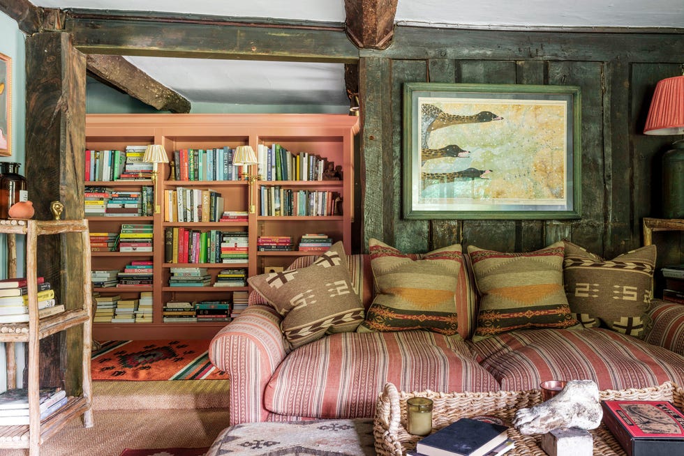 living room with striped couch and large painted bookshelf behind it