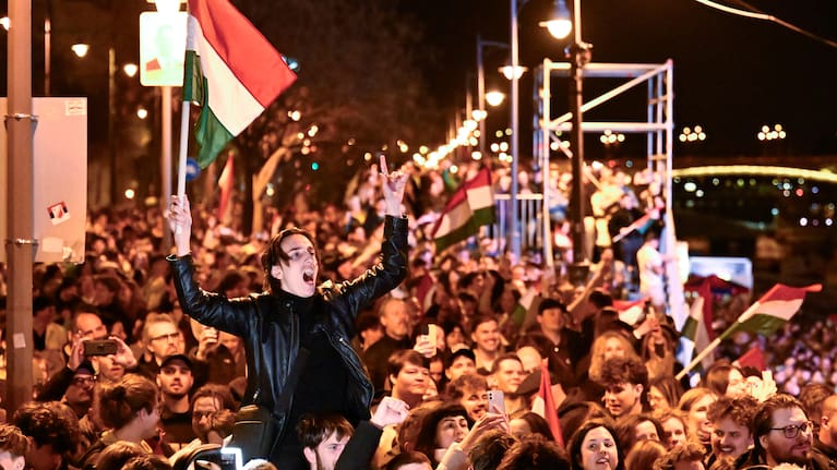 A man waves a Hungarian flag as he celebrates in the streets after the announcement of partial results of the Hungarian parliamentary election in Budapest