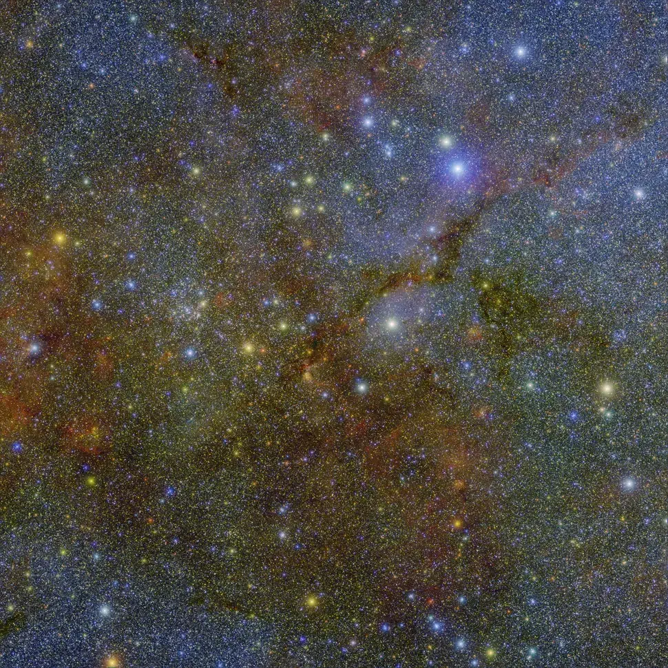 The same region as the header image, but in three different wavelengths assigned the colors green, blue, and red. This SPHEREx observation highlights the dark, dusty lanes that protect the water molecules from the intense radiation generated by newborn stars. 
Image credit: NASA/JPL-Caltech/IPAC/Hora et al.