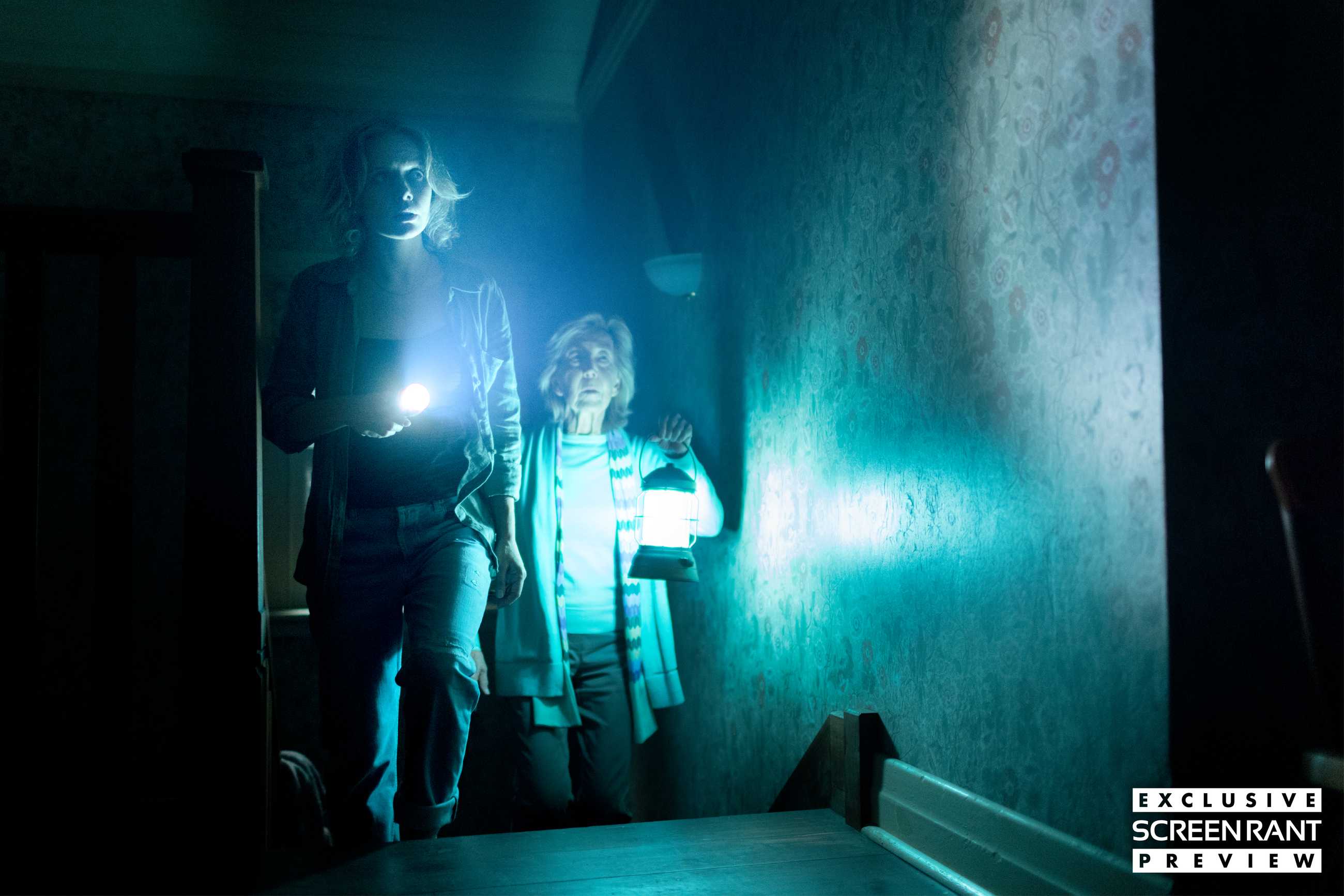 Two characters walk up stairs holding a flashlight and a lantern in Insidious: Out of the Further