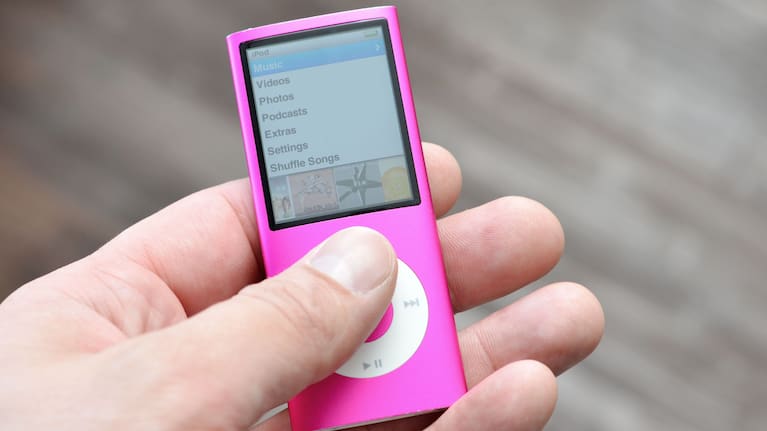 Close up of a man's hand holding an older version of the iPod Nano from Apple