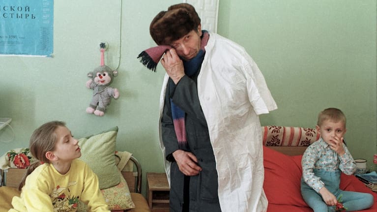 Ivan Kalenda turns away to wipe his tears as he visits his 3-year-old grandson Vitya, right, in the children's cancer hospital ward in Gomel, Belarus, March 19, 1996.