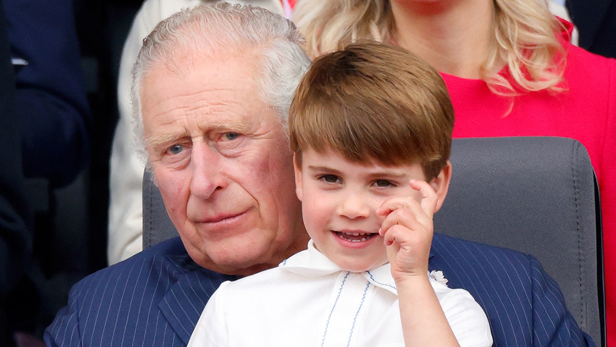 Prince Louis sitting on Prince Charles's lap at the Platinum Pageant in London