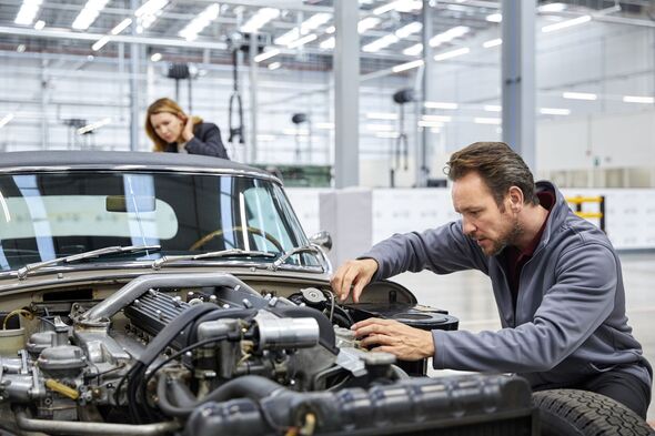 Male engineer repairing vintage car in industry Male engineer repairing vintage car in industry