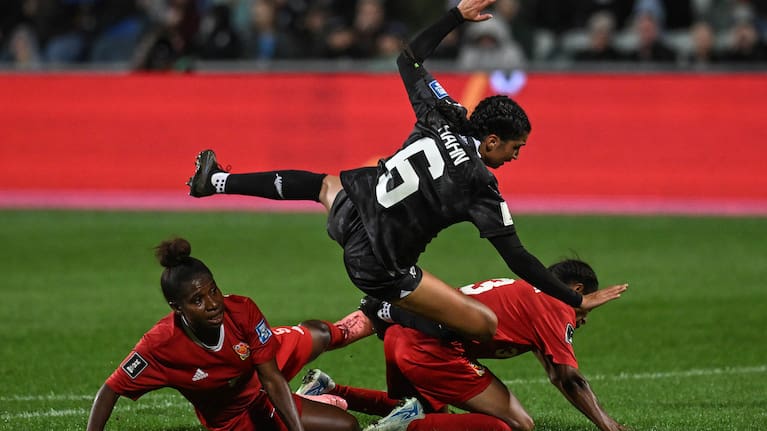 Maya Hahn of New Zealand falls from the tackle by Olivia Upaupa of Papau New Guinea and Anashtasia Gunemba of Papau New Guinea.