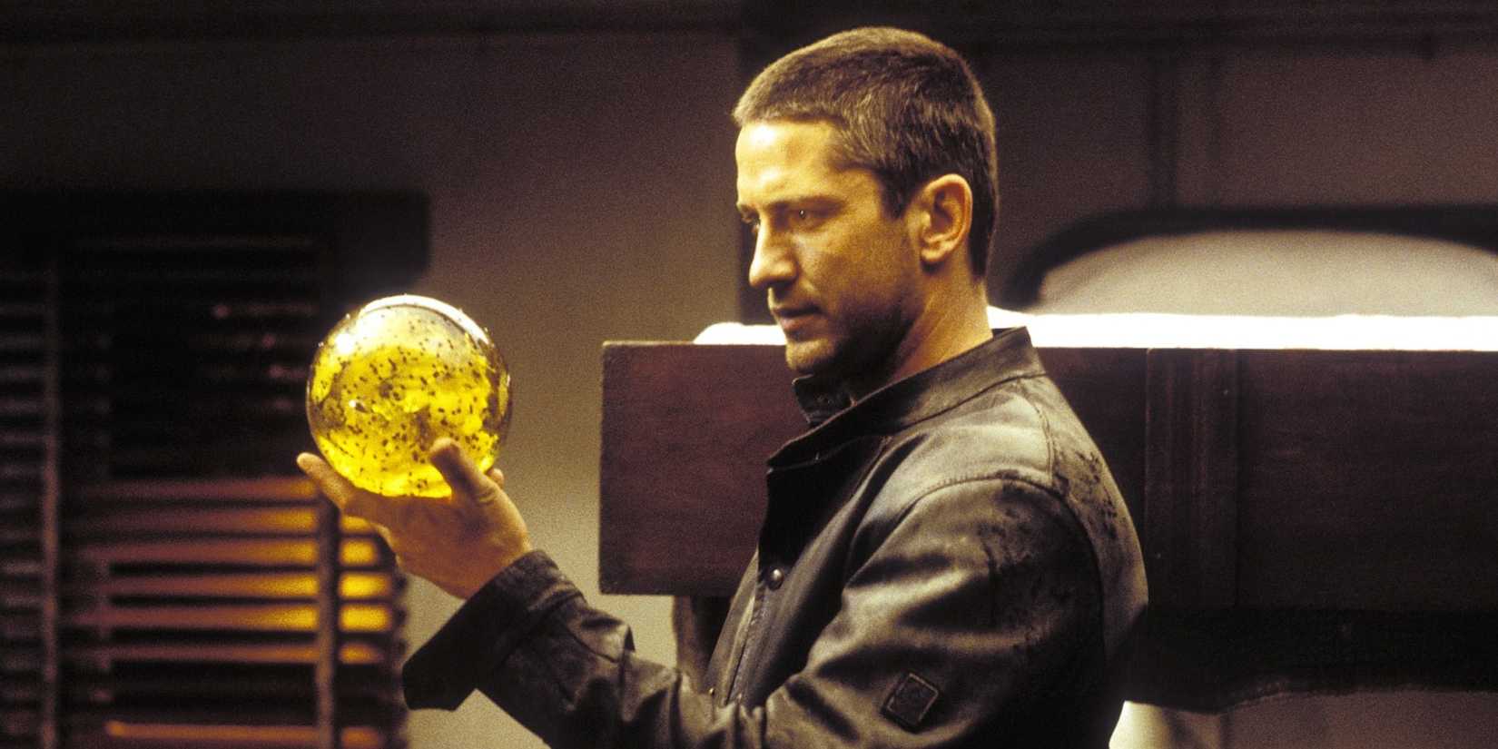 Gerard Butler holding and looking at a yellow orb in Lara Croft Tomb Raider 2 Cradle of Life