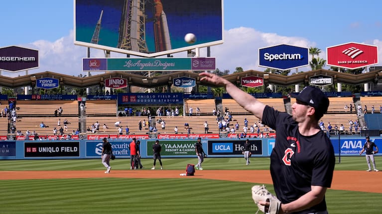 Members of the Cleveland Guardians warm up as NASA'S Artemis ll rocket is seen prior to launch from Launch Complex 39B at Kennedy Space Center on the big screen above them prior to a baseball game against the Los Angeles Dodgers.