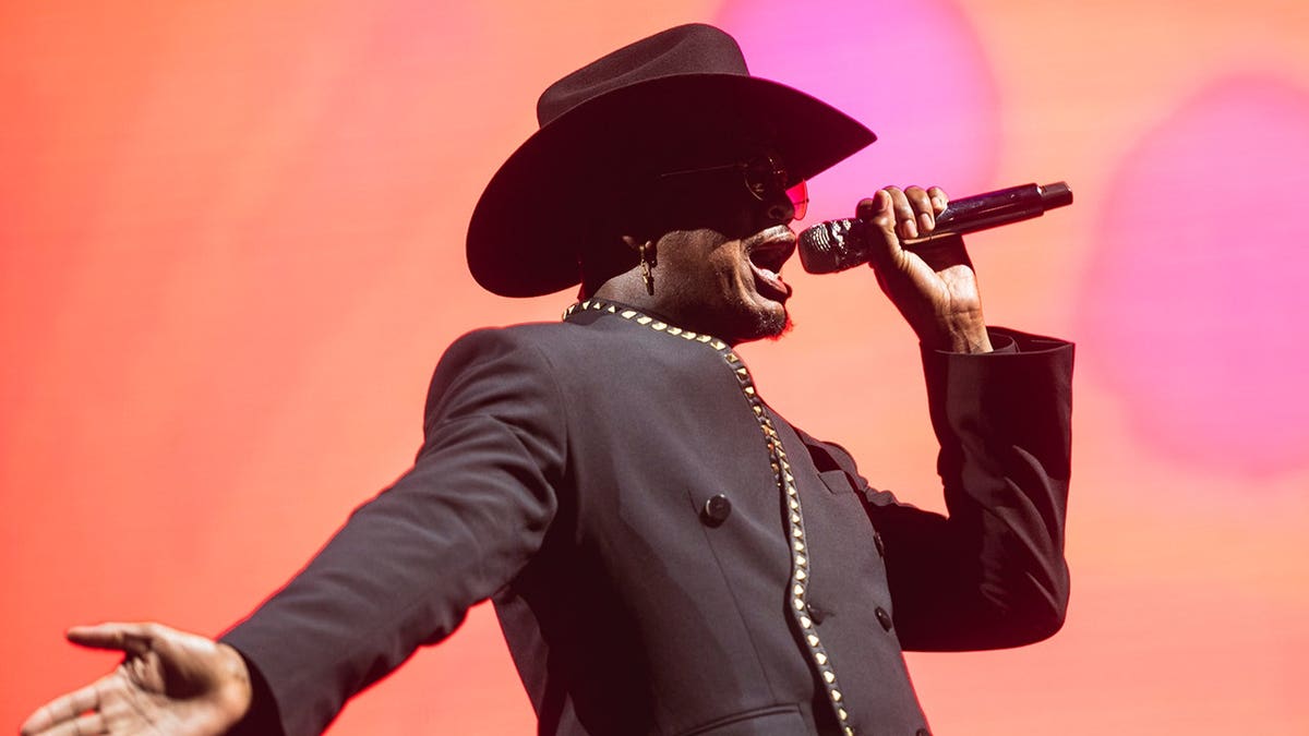 Ne-Yo performs on stage wearing a cowboy hat