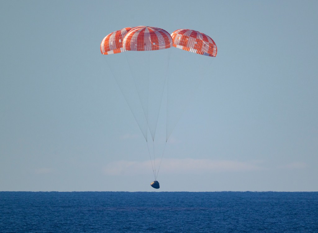 NASA’s Orion spacecraft with Artemis II crewmembers NASA astronauts Reid Wiseman, commander; Victor Glover, pilot; Christina Koch, mission specialist; and CSA (Canadian Space Agency) astronaut Jeremy Hansen, mission specialist aboard is seen under parachutes as it lands in the Pacific Ocean off the coast of California, Friday, April 10, 2026. NASA’s Artemis II mission took Wiseman, Glover, Koch, and Hansen on a 10-day journey around the Moon and back to Earth. Following a splashdown at 8:07 p.m. EDT, NASA, U.S. Navy, and U.S. Air Force teams are working to bring the crewmembers and Orion spacecraft aboard USS John P. Murtha.