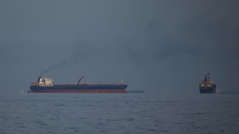 Oil tankers and cargo ships line up in the Strait of Hormuz as seen from Khor Fakkan, United Arab Emirates