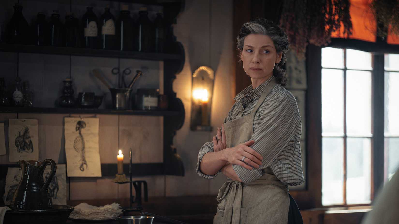 Claire standing in her surgery in Outlander season 8