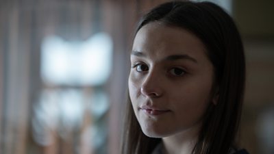 A close up shor of a young girl's face, half in shadow