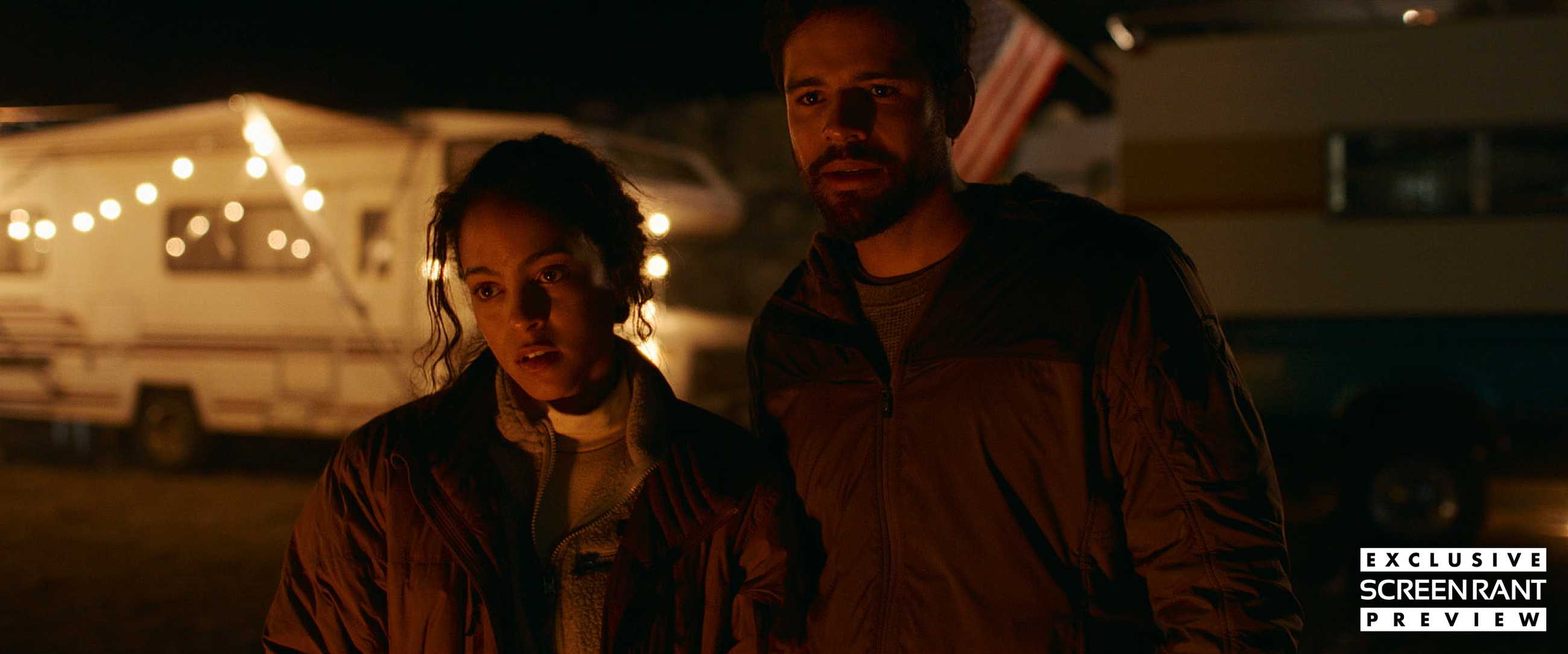Maddie and Tyler look quizzically at something in a trailer park at night in Passenger
