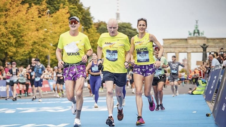 Paul Barclay competing in the 2025 Berlin Marathon, alongside volunteer guides Tony Watson (left) and Rosie Hay.