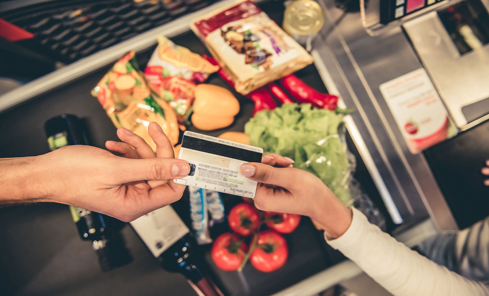 Customer handing over their credit card at the supermarket checkout (Getty Images/GeorgeRudy)