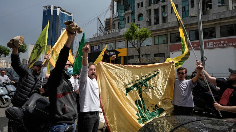 People chant slogans while holding Hezbollah flags in Dahiyeh, Beirut's southern suburbs, Lebanon, Friday, April 17, 2026, following a ceasefire between Israel and Hezbollah.