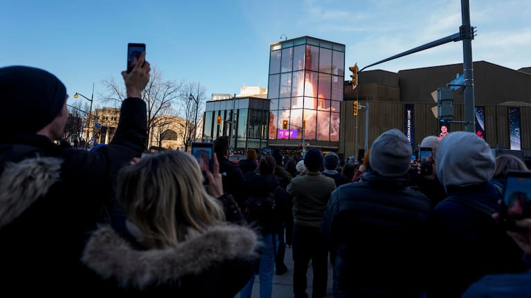 People watch the lift off of Artemis II on a livestream displayed on the Kipnes Lantern of the National Arts Centre in Ottawa, Ontario